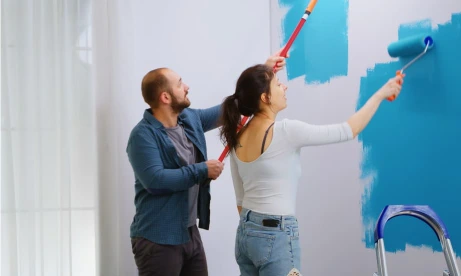 Pareja pintando casa